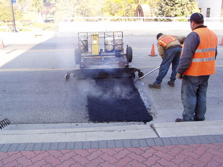 Asphalt heated and raked prior to rolling